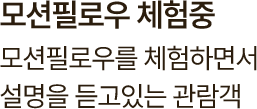 모션필로우를 체험하면서 설명을 듣고 있는 관람객